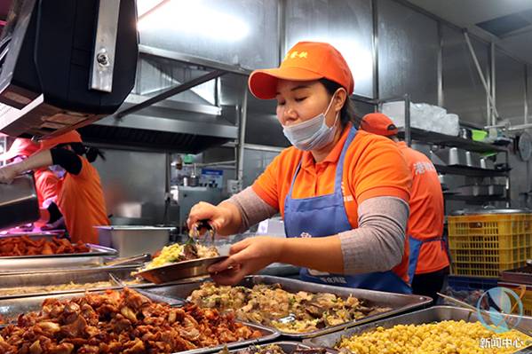 饭堂工作人员分发鱼块